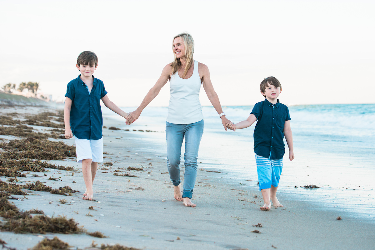 Founder, Susan Day, walking on the beach with her two sons.